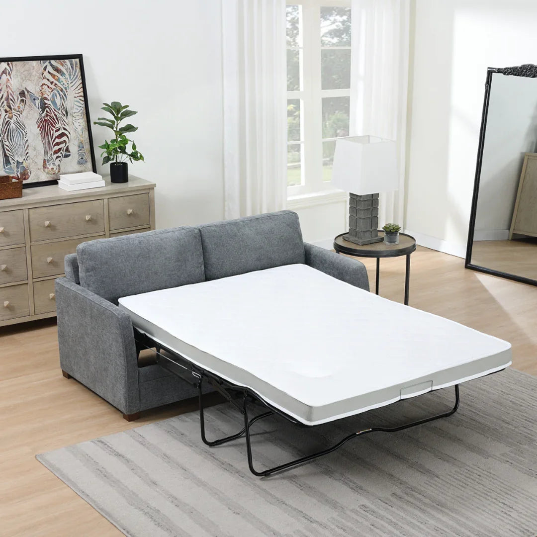Grey foam sofa bed extended in living room with light wood flooring and modern decor