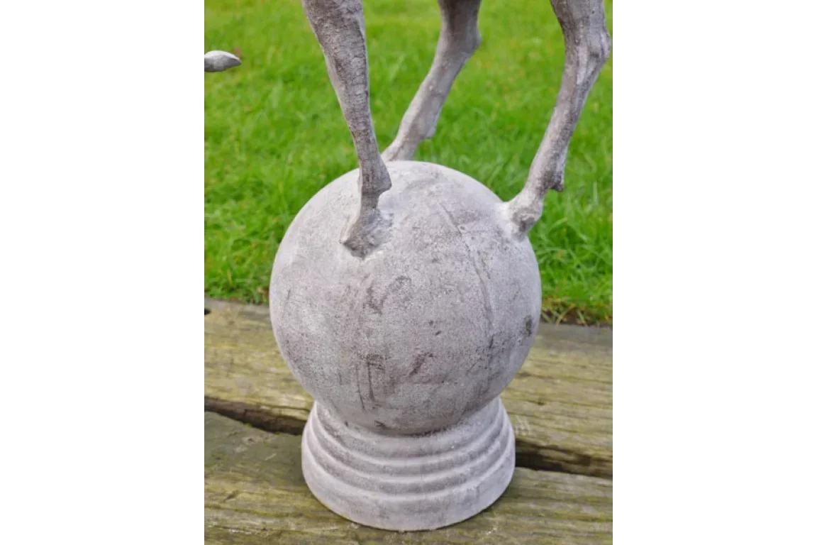 stone garden ornament with animal legs standing on round sphere base, outdoor display