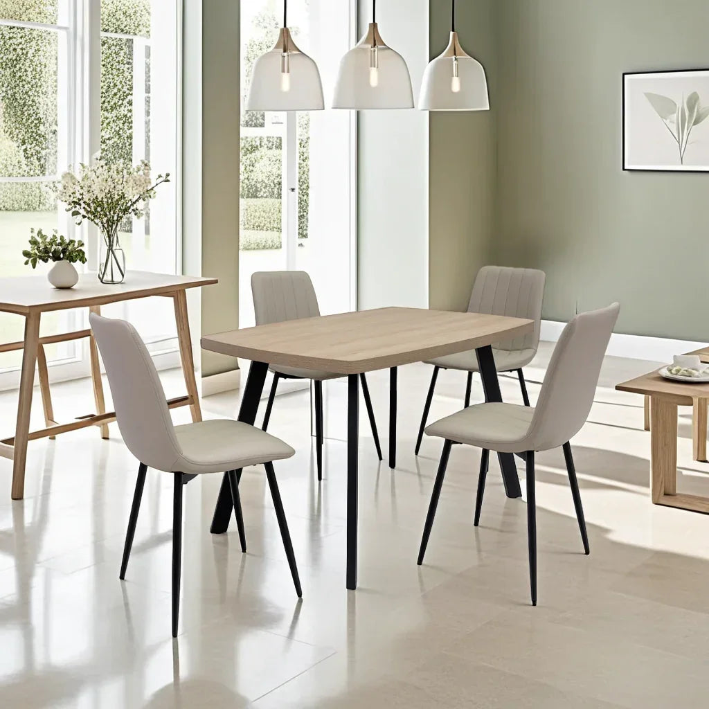 Modern dining table set with light wood top and four beige upholstered chairs in bright room