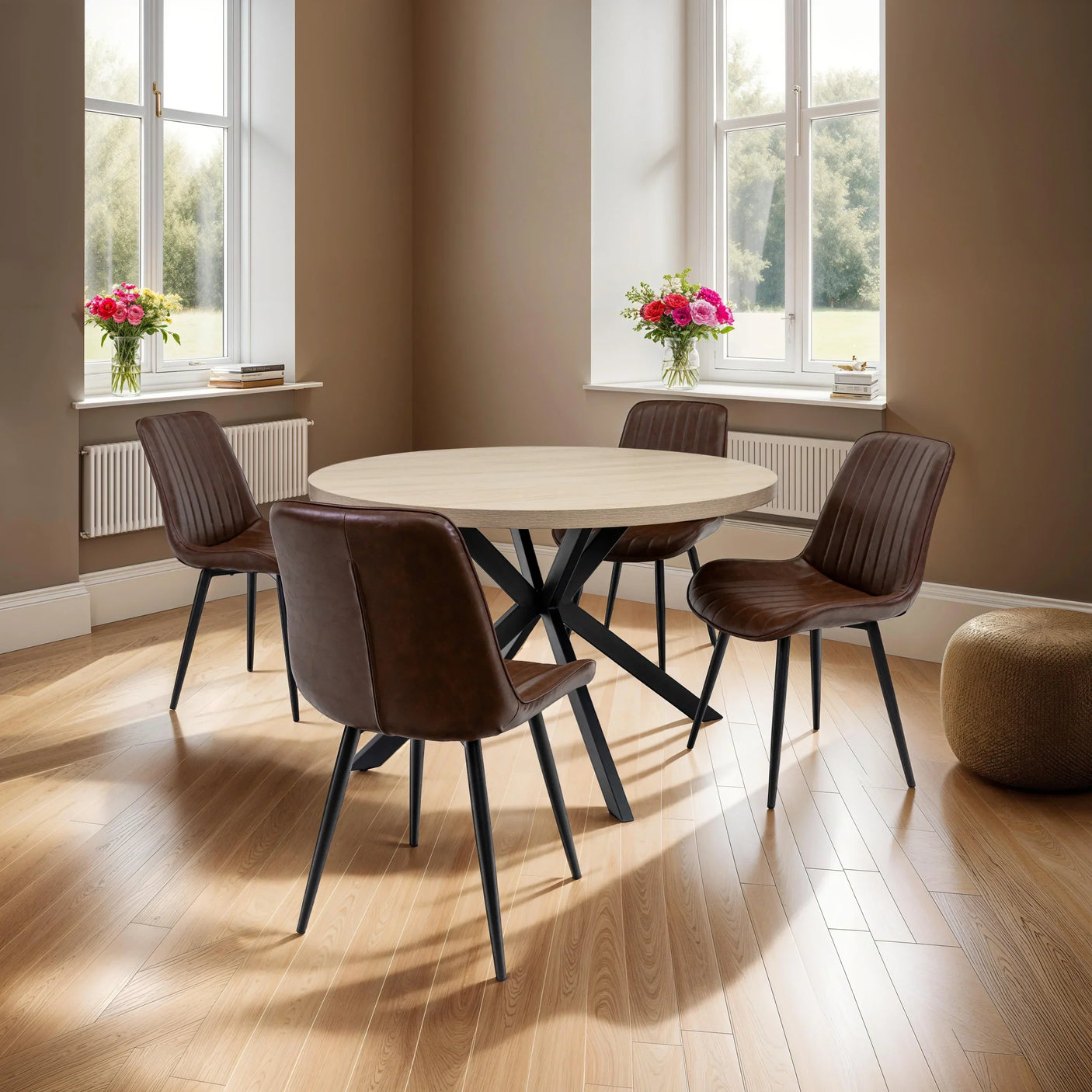 Round dining table with light wood top and four brown faux leather chairs in modern room