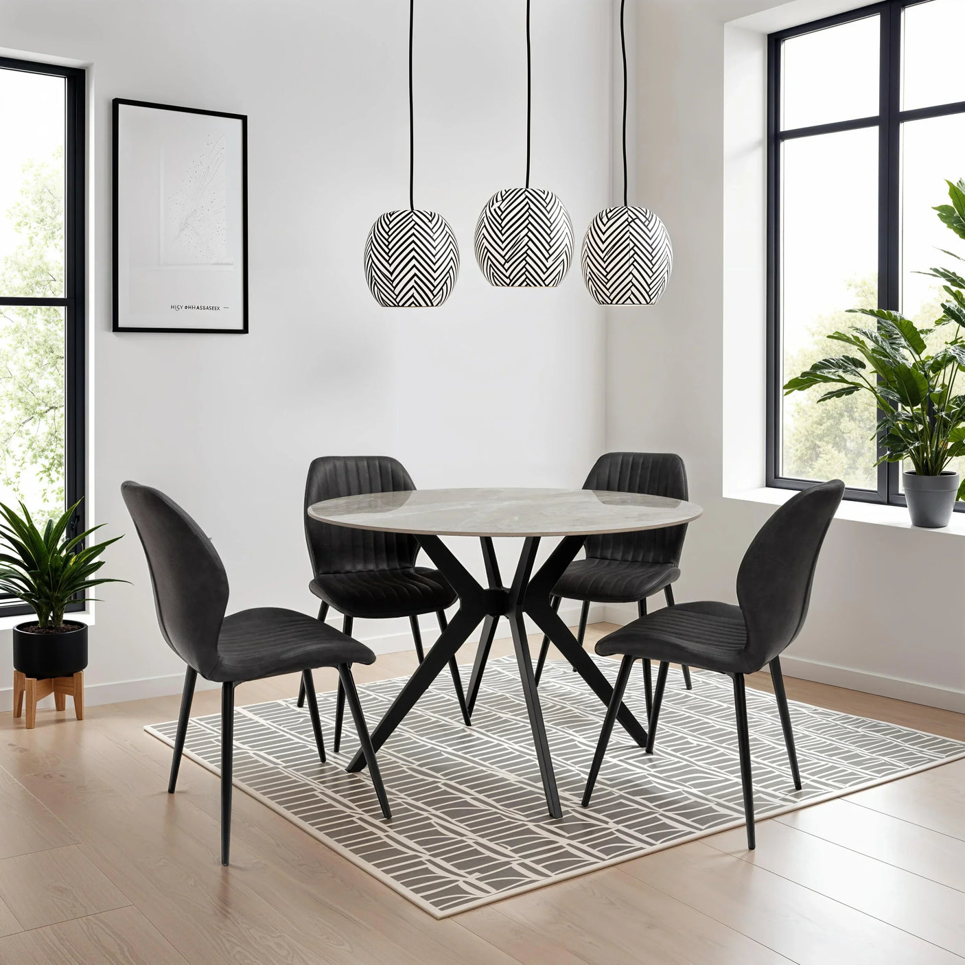 Modern round dining table with black legs and four black velvet chairs in bright dining room