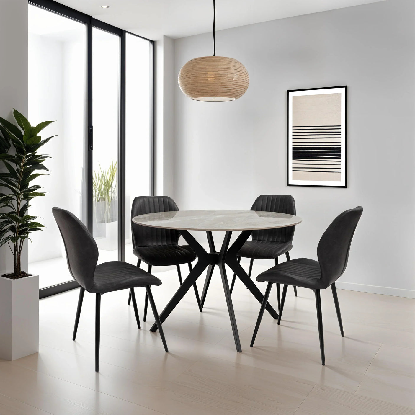 Round marble dining table with four black velvet chairs in modern dining room