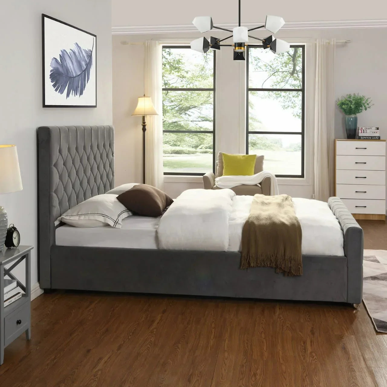 Grey upholstered bed with tufted headboard in modern bedroom with large windows