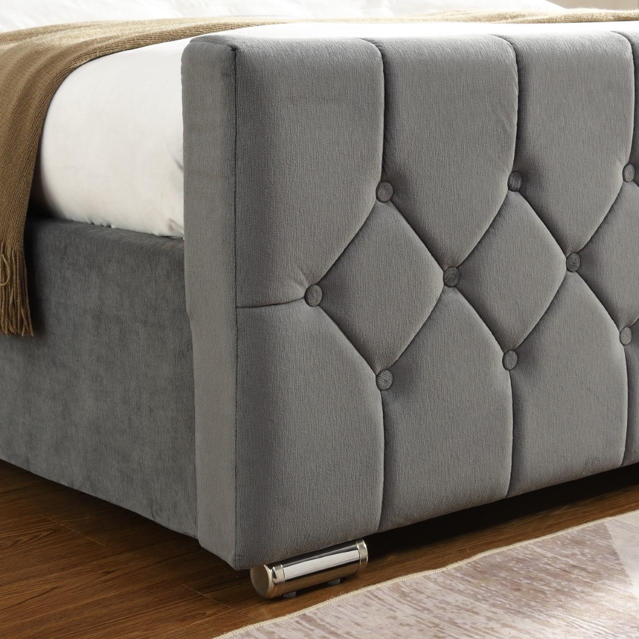 Grey upholstered bed frame with quilted headboard and chrome feet on wooden floor