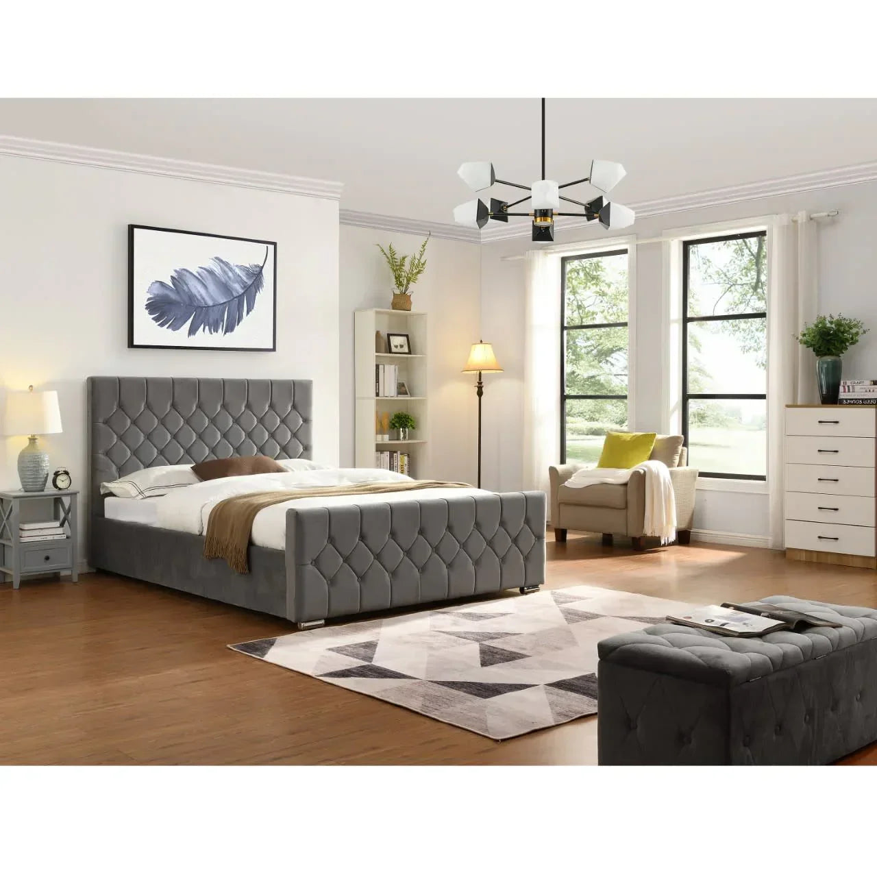 Grey upholstered bed with tufted headboard in modern bedroom, wood floor and large windows