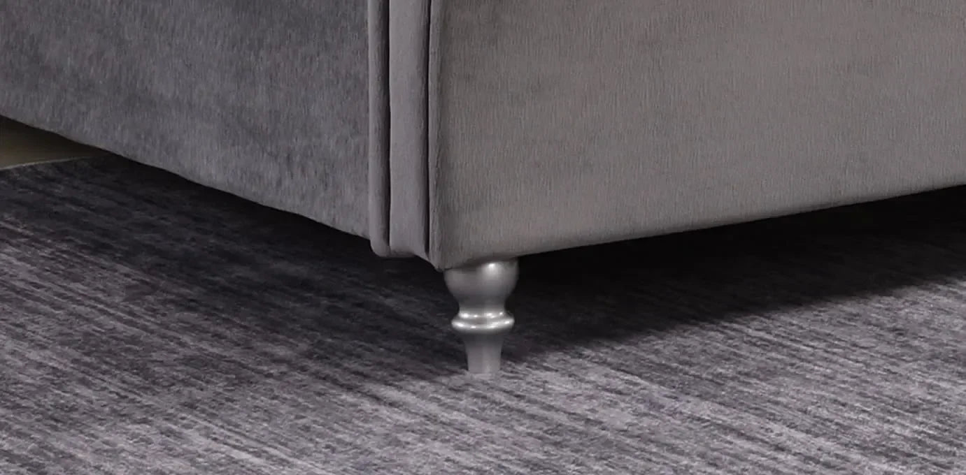 Grey sofa corner with turned wood leg on textured rug