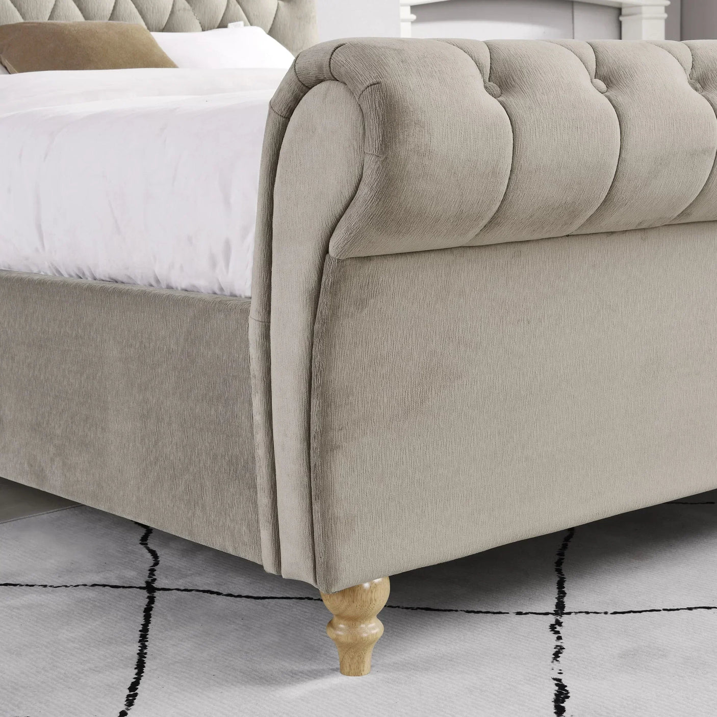 Beige upholstered bed frame with deep buttoned footboard and wooden legs on modern rug