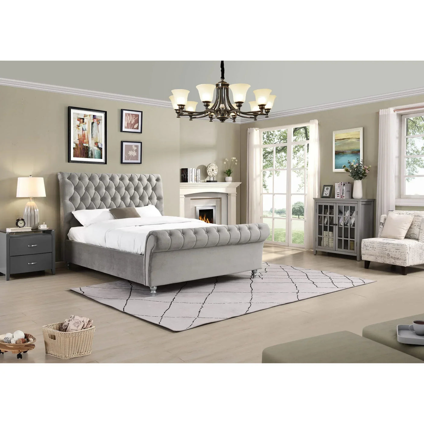 Grey upholstered bed with tufted headboard in modern bedroom with fireplace and chandelier