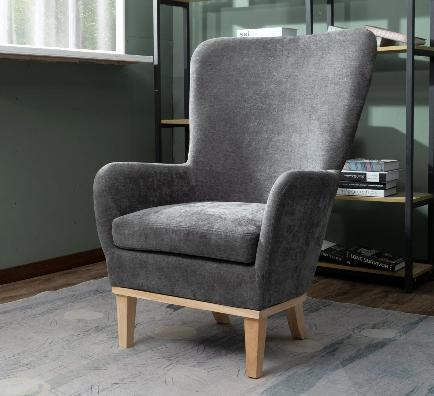 Grey velvet armchair with light wooden legs in a modern living room corner