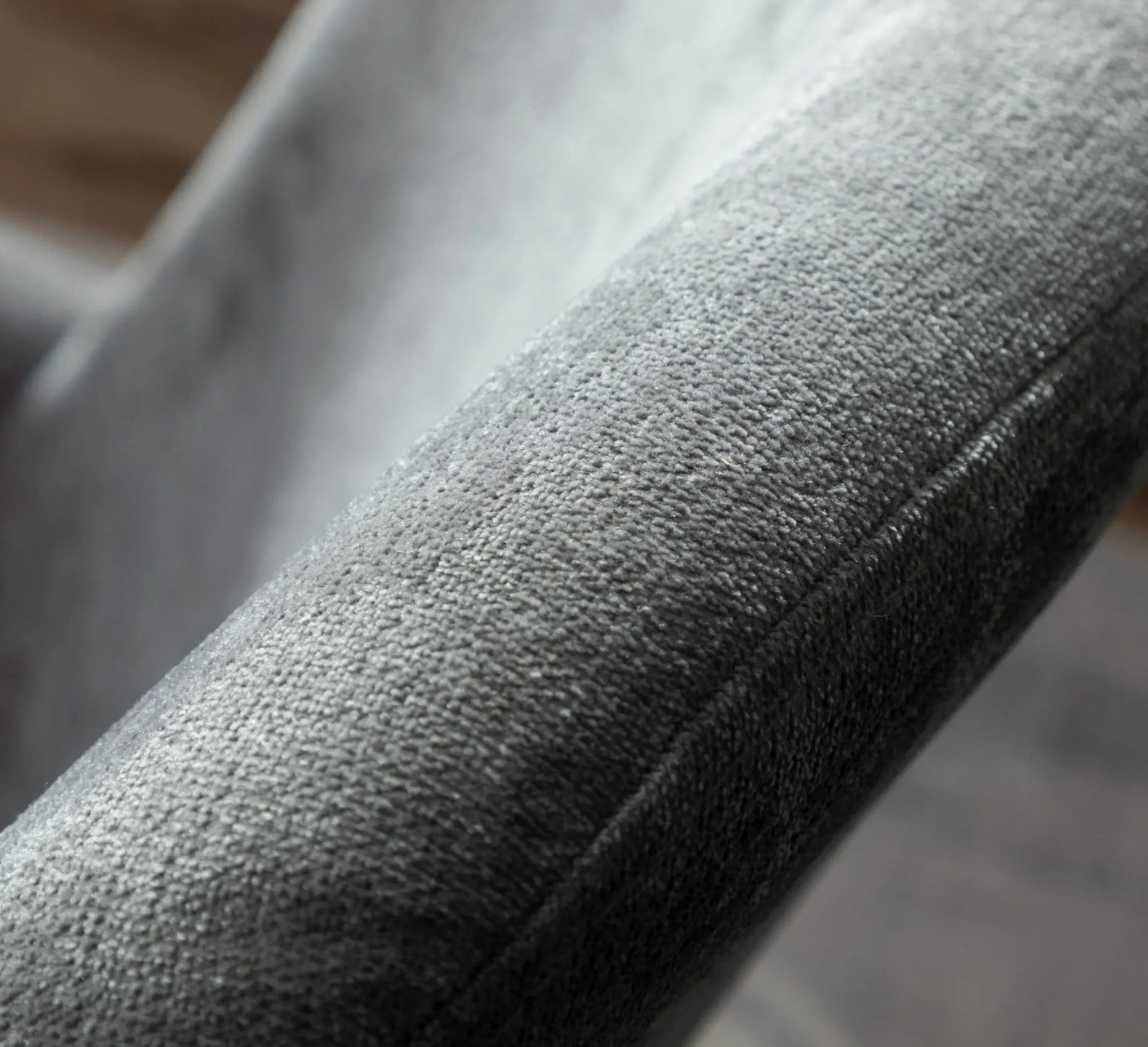 Close-up of grey fabric sofa armrest with soft textured upholstery