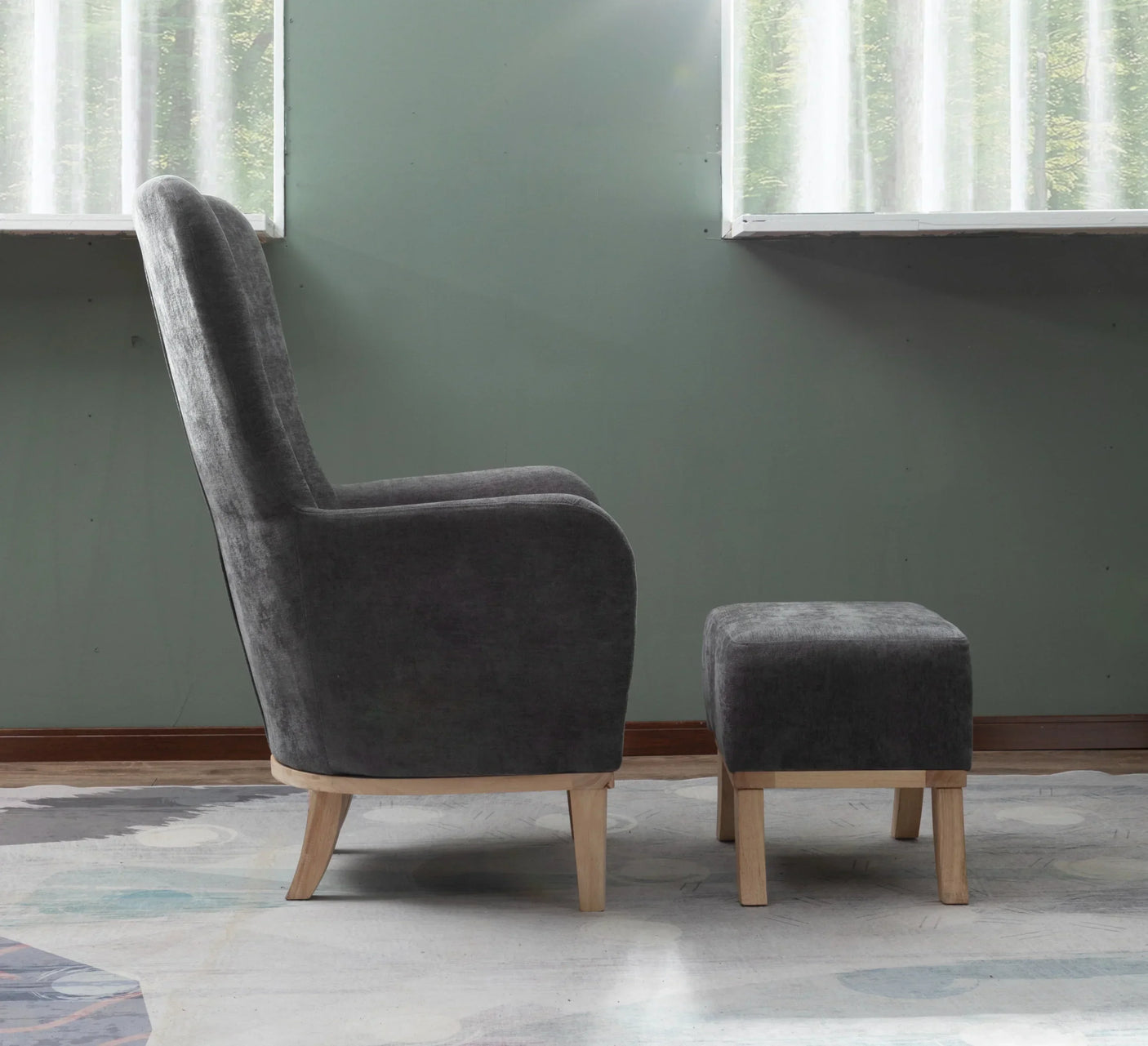 Grey fabric armchair with matching footstool and light wood legs in modern living room