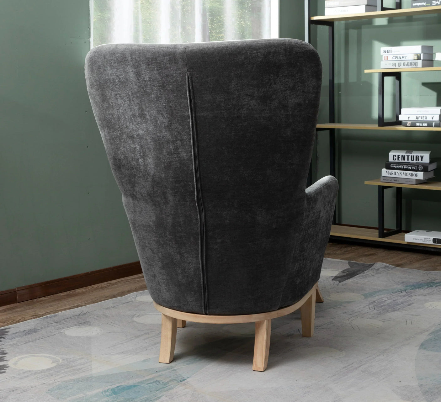 High back dark grey fabric armchair with light wood legs in living room setting