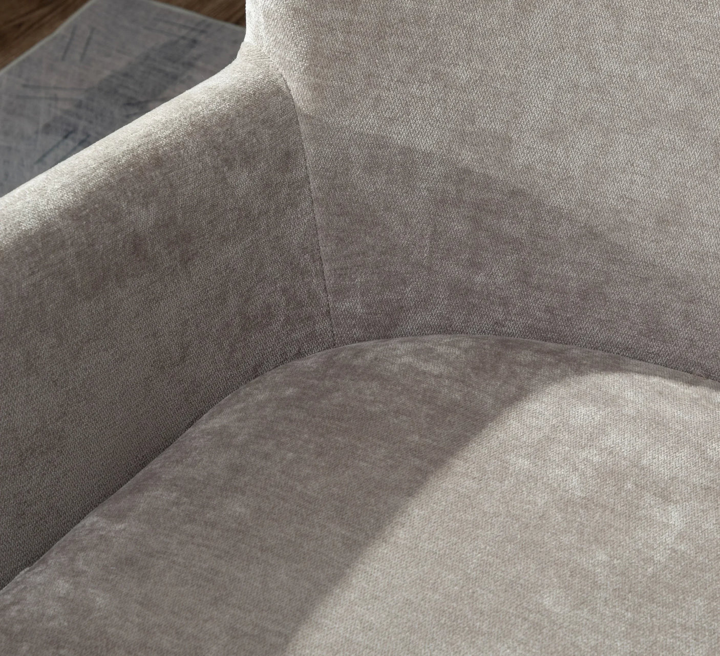 Close-up of beige fabric sofa arm and seat cushion with soft texture