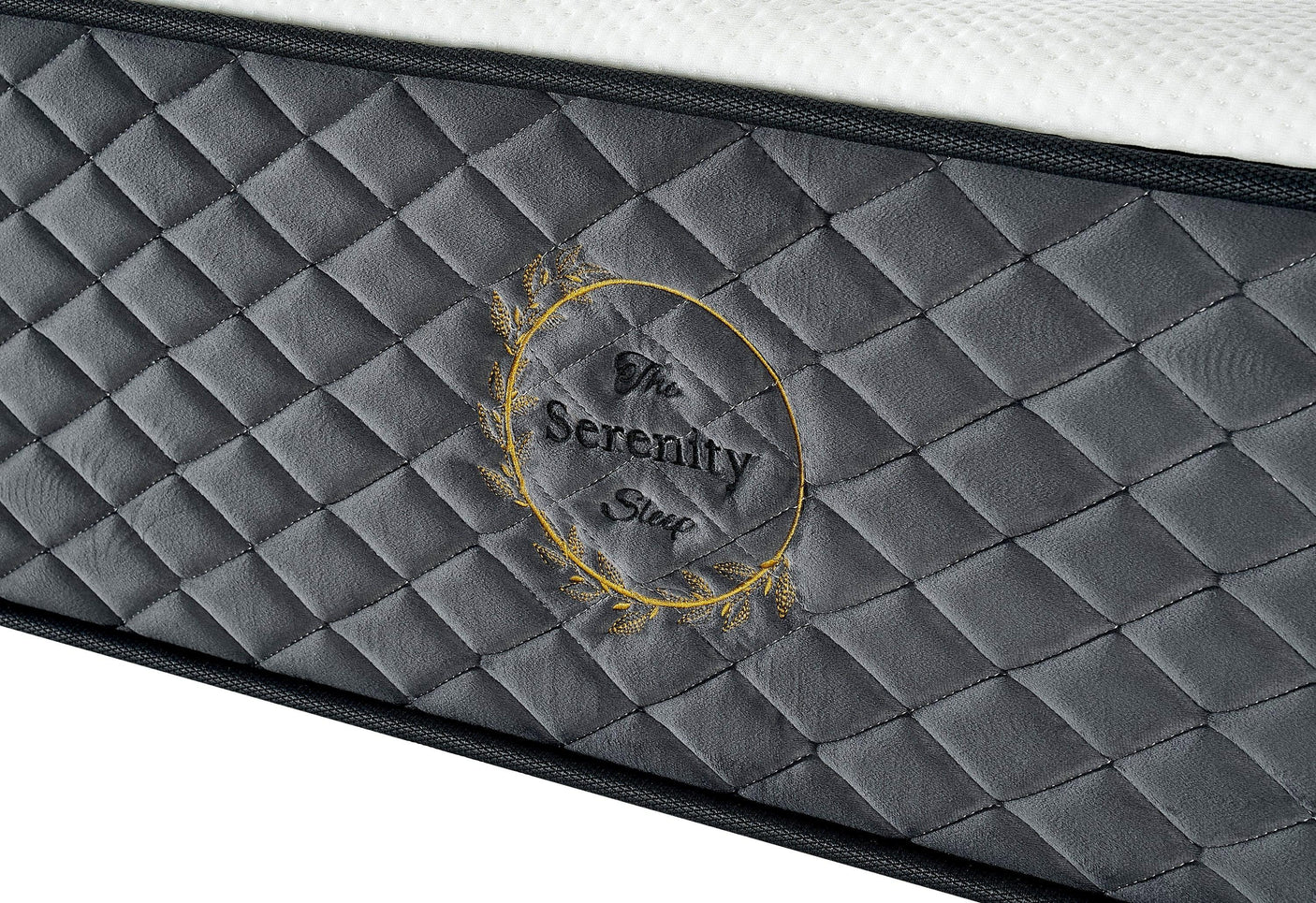 Grey quilted mattress side panel with stitched Serenity Sleep logo and texture detail