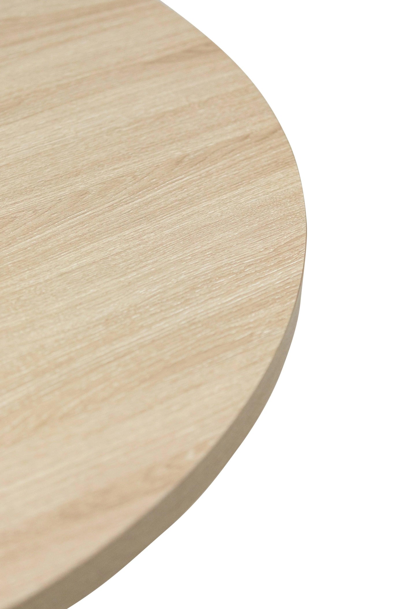 Closeup of round light oak wood dining table top with visible grain texture