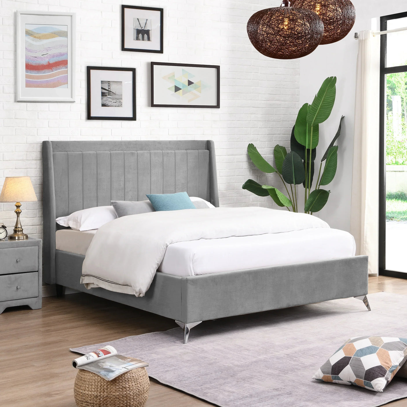 Grey upholstered bed with high headboard in modern bedroom with wall art and indoor plant