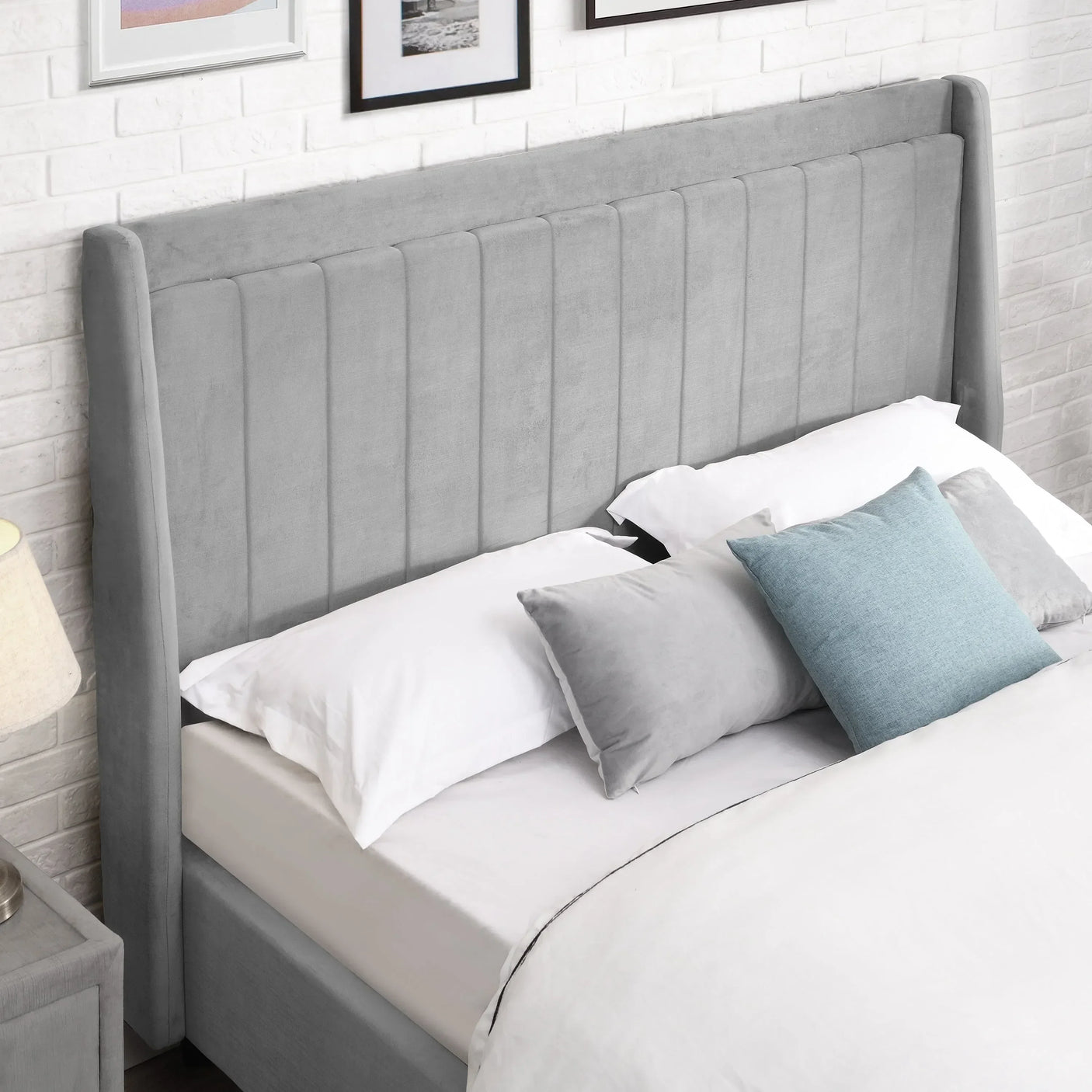 Grey upholstered bed with vertical panel headboard, white bedding and decorative pillows