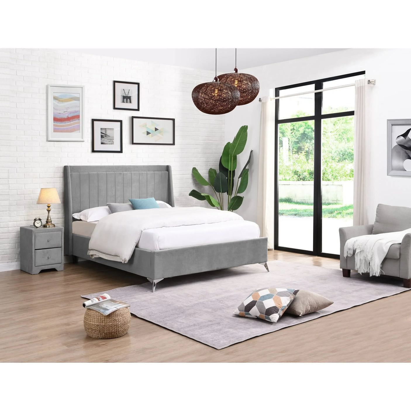 Grey upholstered bed with padded headboard in modern bedroom setting with armchair and side table