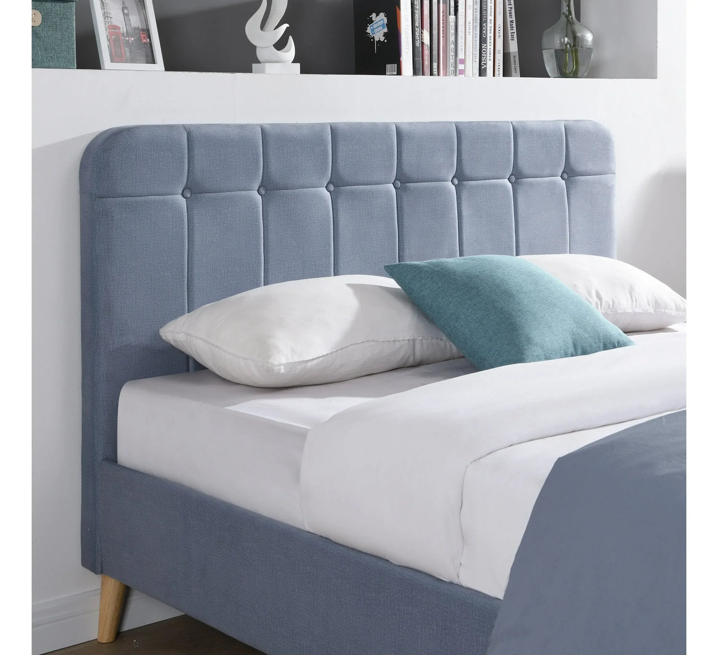 Light grey fabric bed frame with padded headboard and pillows in modern bedroom