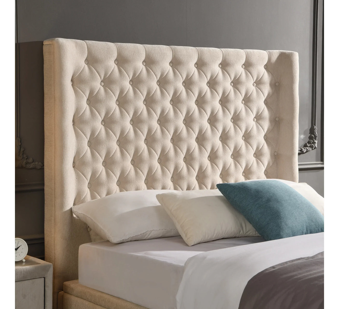 Beige upholstered bed with deep buttoned headboard and scatter cushions