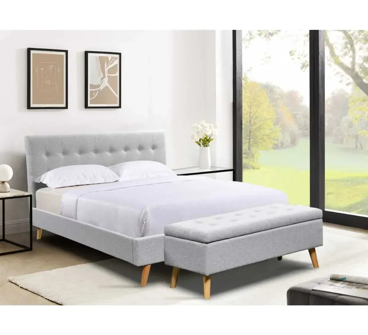 Light grey upholstered bed frame with matching bench in modern bedroom with large window