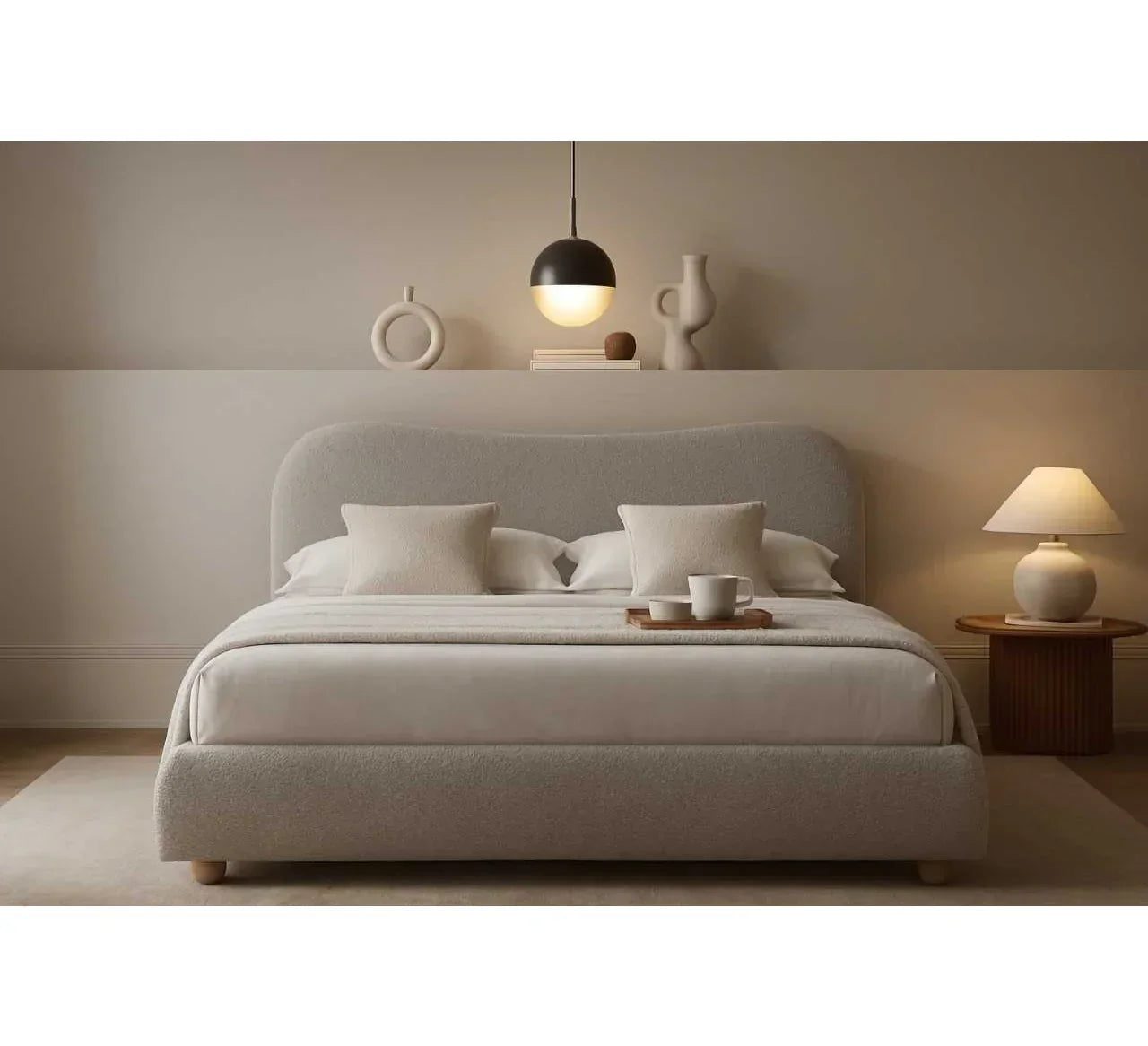 Modern upholstered bed with cream fabric, pillows, and bedside table in neutral bedroom
