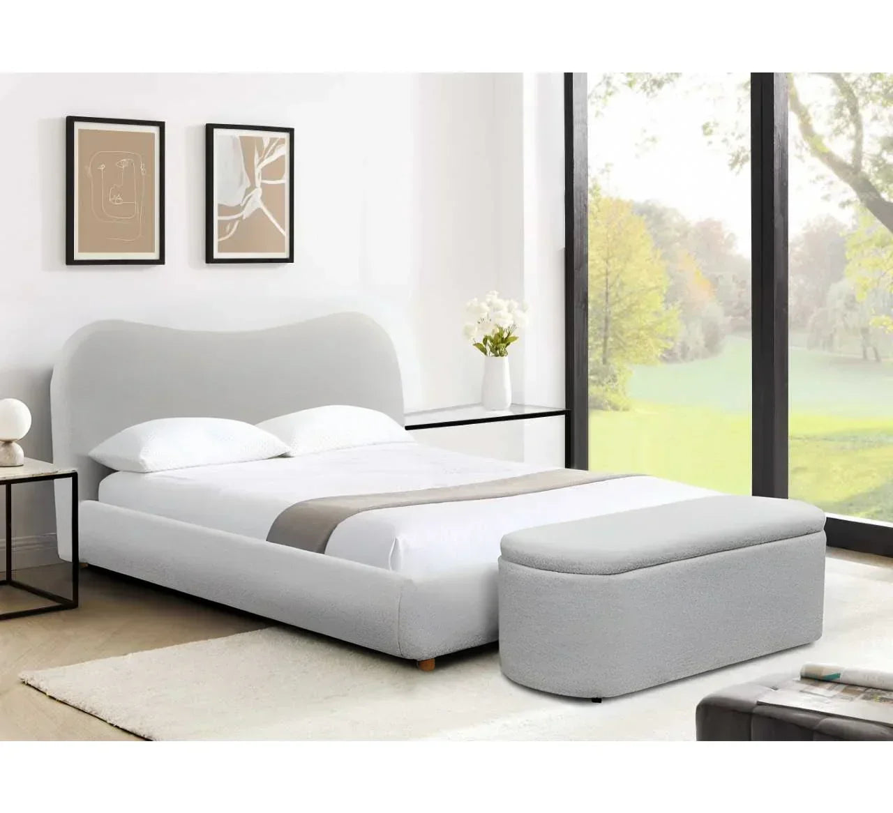 Grey upholstered bed with matching ottoman storage bench in modern bedroom with large window
