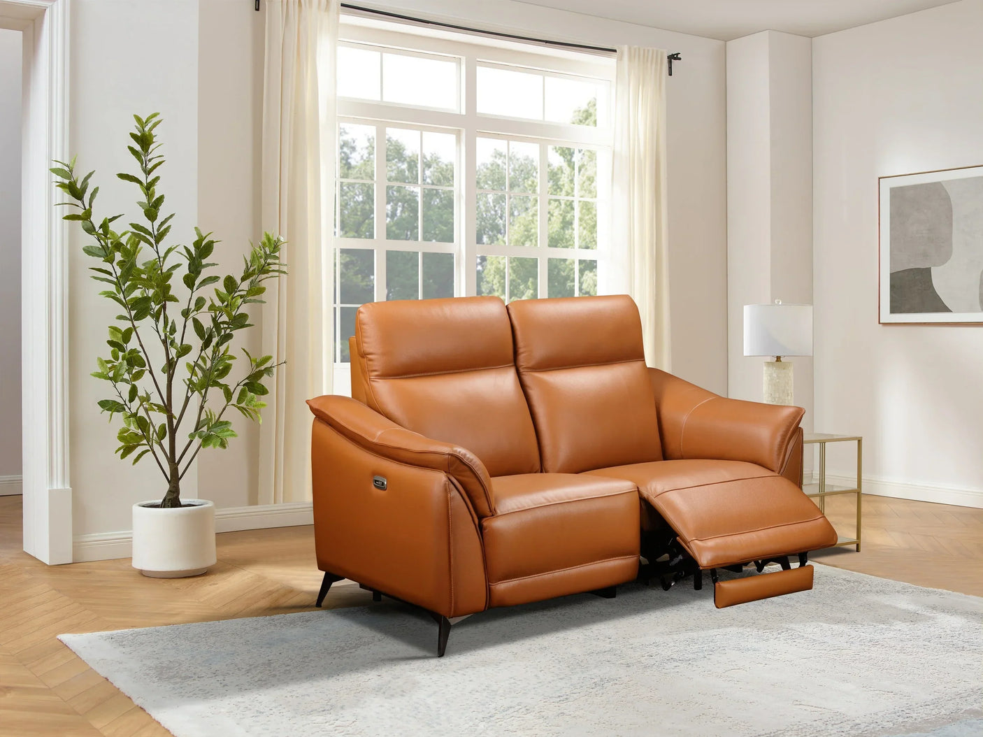 Tan leather recliner sofa in modern living room with light rug and large window