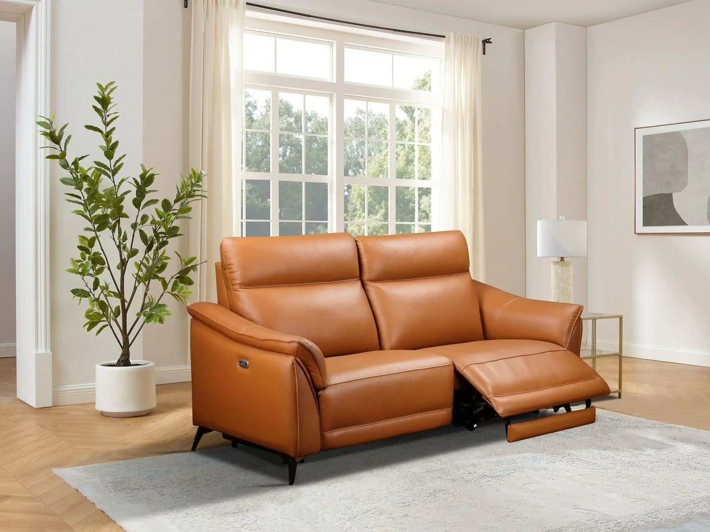 Tan leather reclining sofa with metal legs in bright living room setting