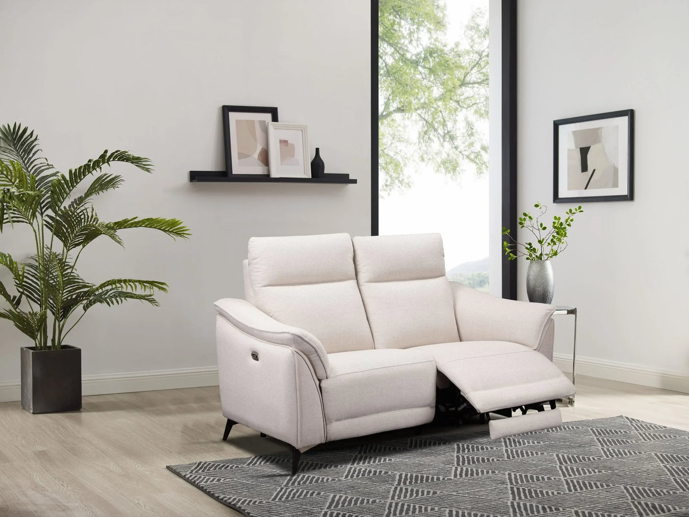 Beige fabric recliner sofa in modern living room with patterned rug and indoor plants