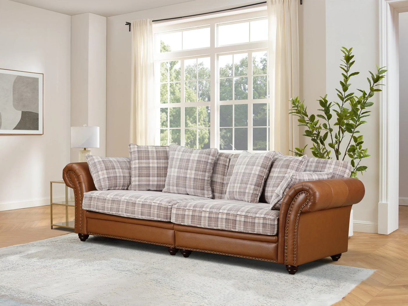 Brown leather and plaid fabric sofa with studded arms in a bright living room