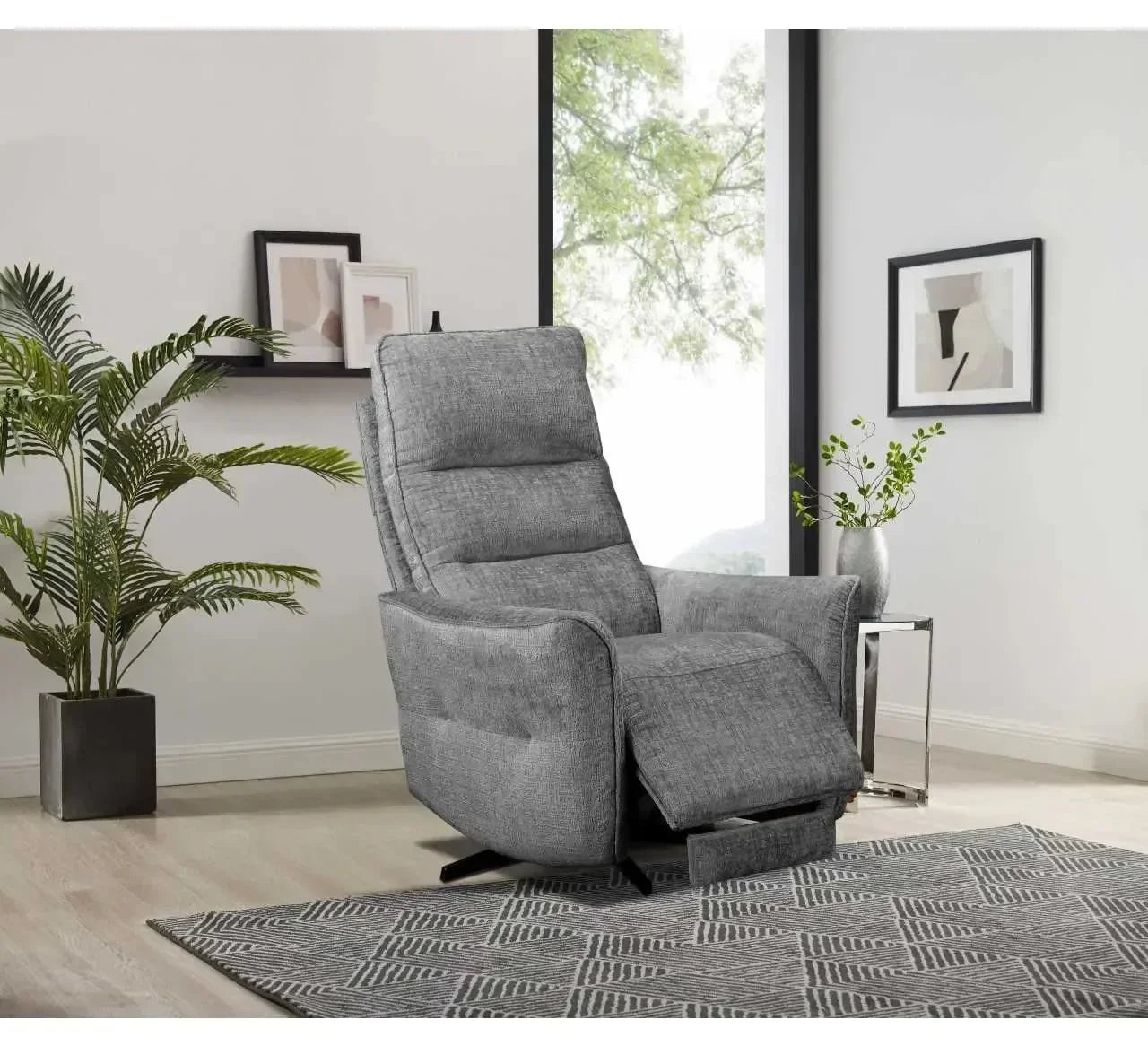 Grey fabric recliner chair with footrest in modern living room with plants and wall art
