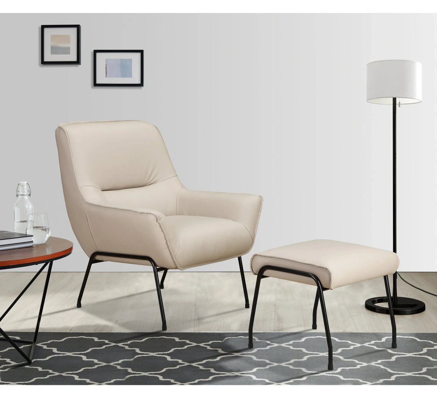 Beige accent chair with matching footstool and black metal legs on patterned rug