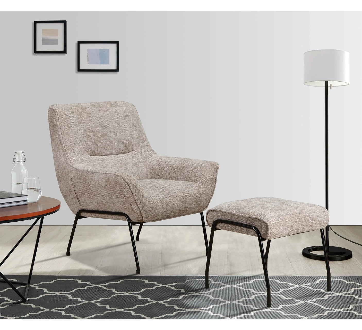 Beige fabric accent chair with metal legs and matching footstool on patterned rug