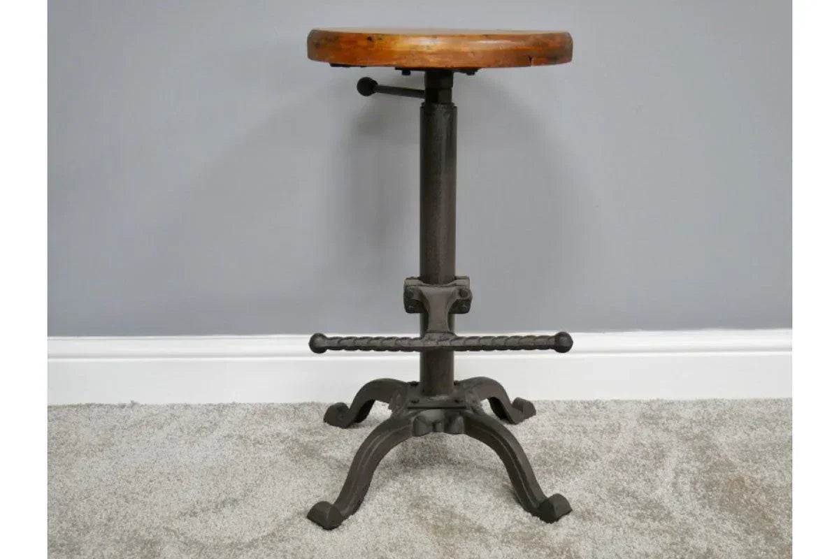 Industrial bar stool with wooden seat and black metal base on grey carpet