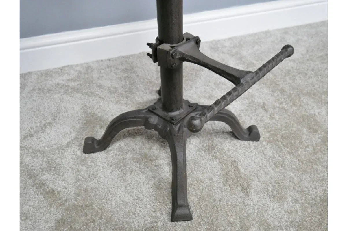 Industrial metal table base with footrest on light carpet