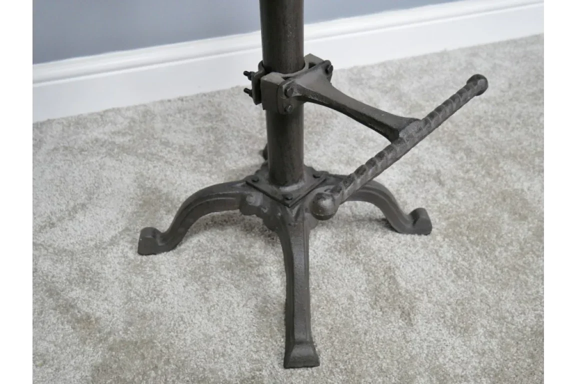 Industrial cast iron table base with crank handle on carpeted floor