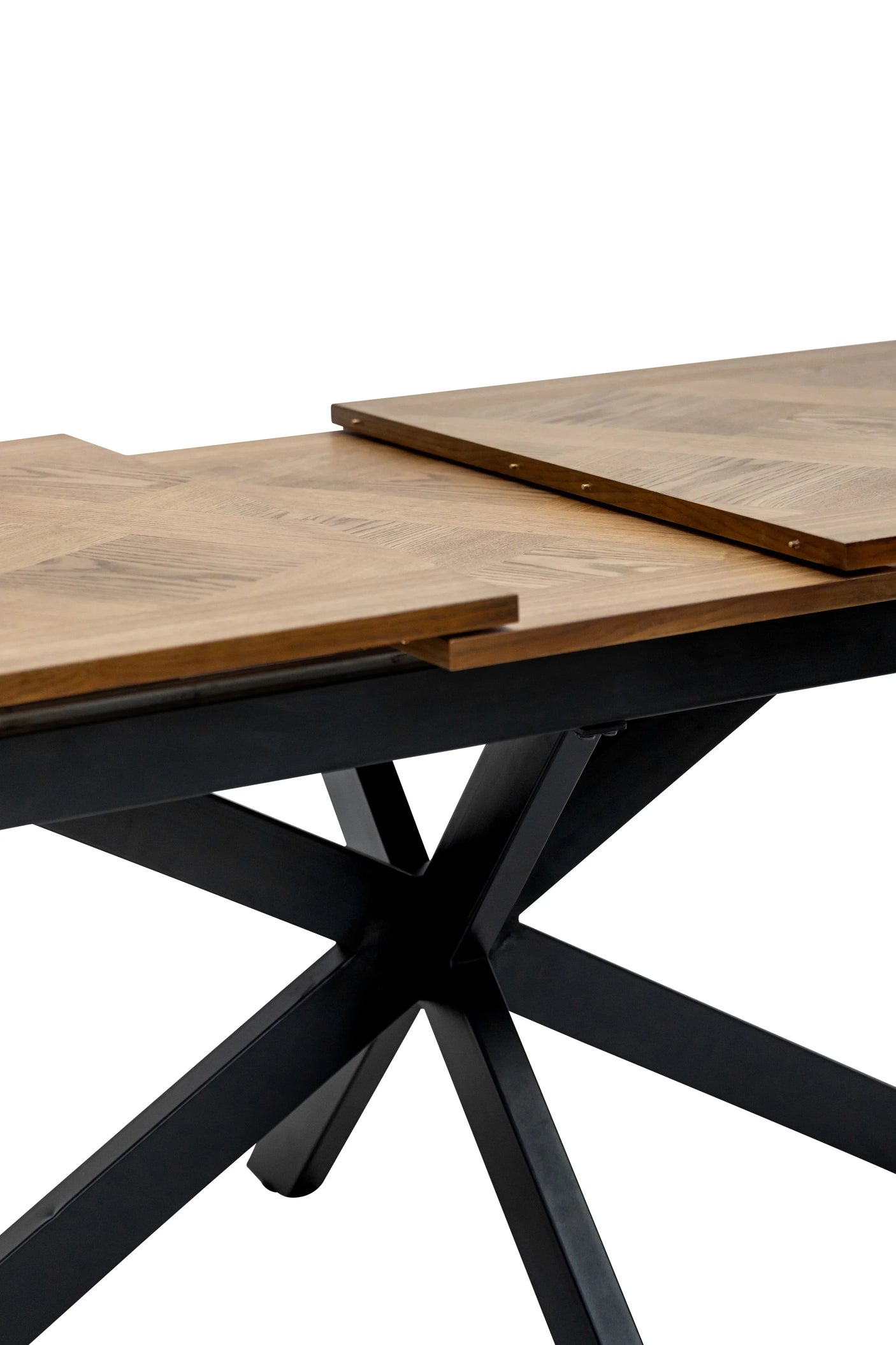 Wood dining table with extendable top and black crossed metal legs, close-up view