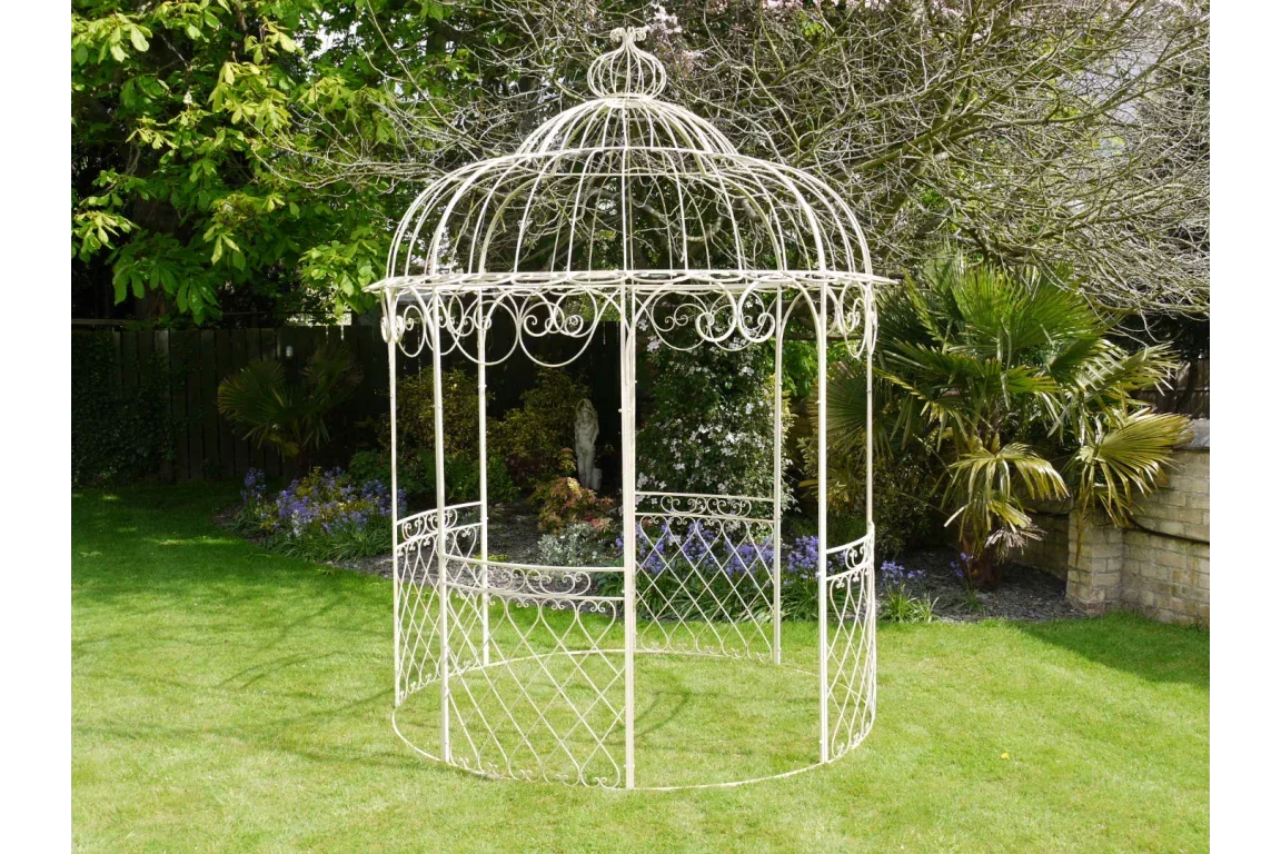 Cream metal garden gazebo with ornate scrollwork on lawn