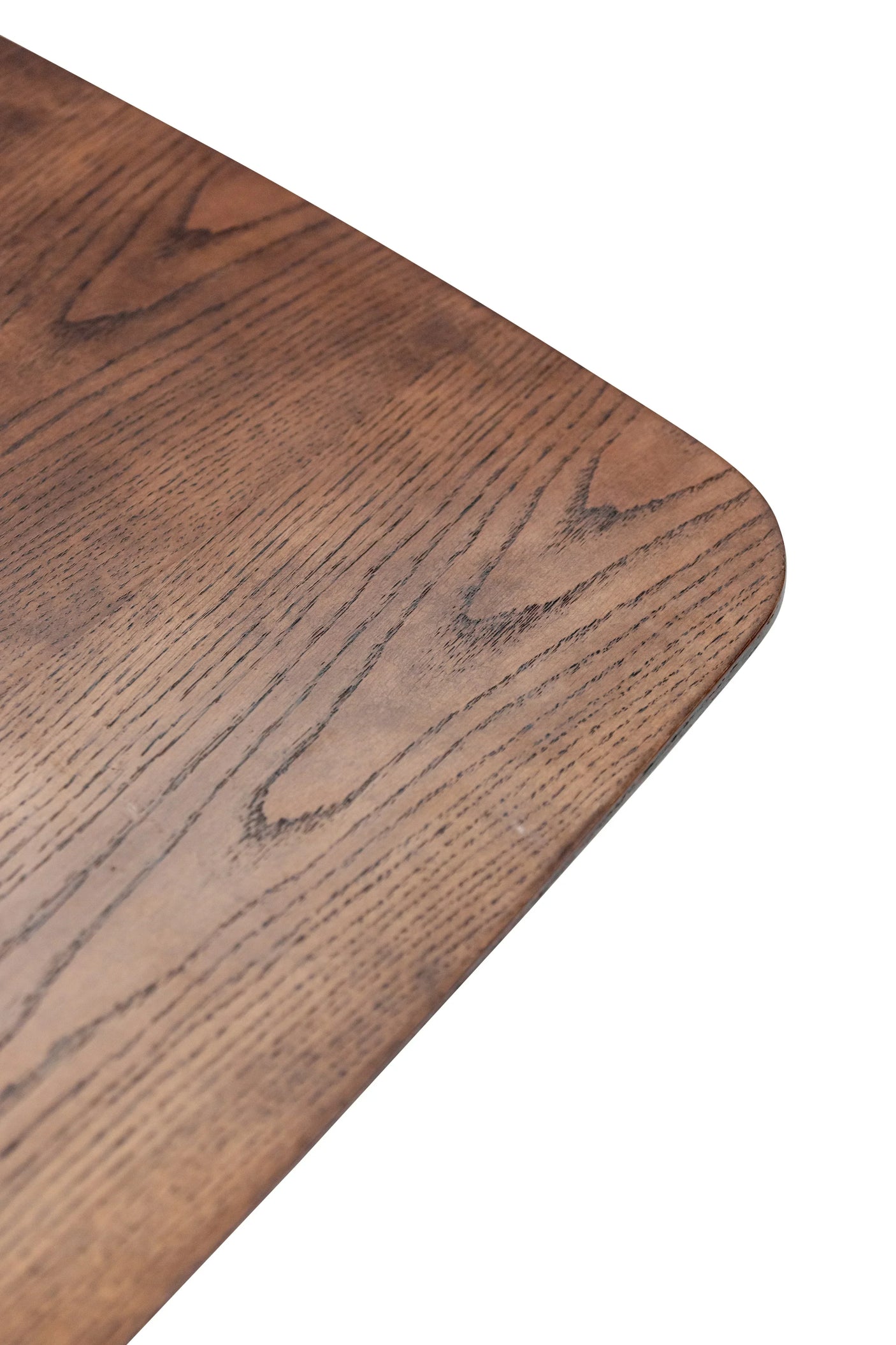 Corner detail of wooden dining table with natural grain and smooth finish