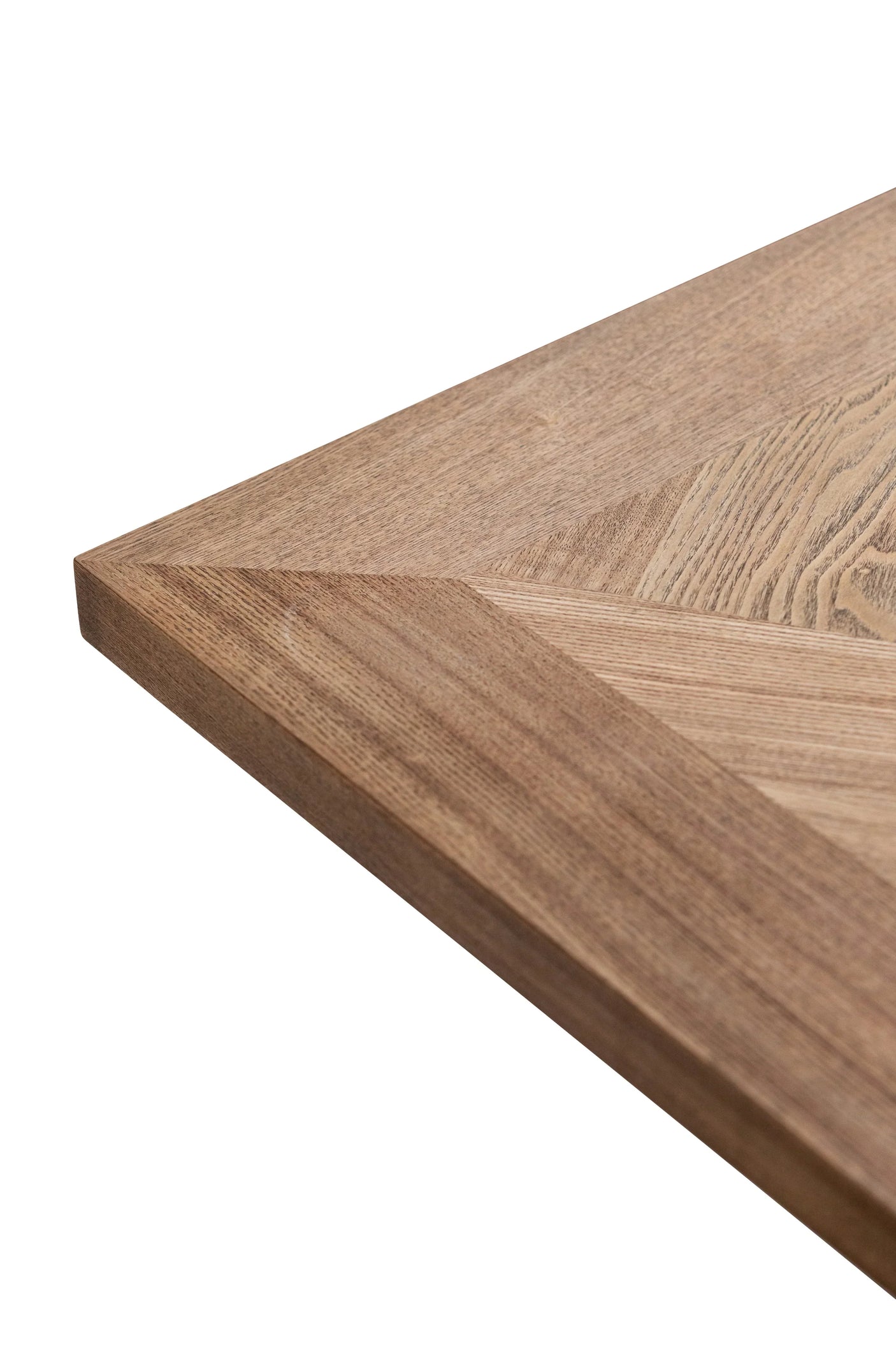 Close-up of natural wood dining table corner with visible grain and angled edge