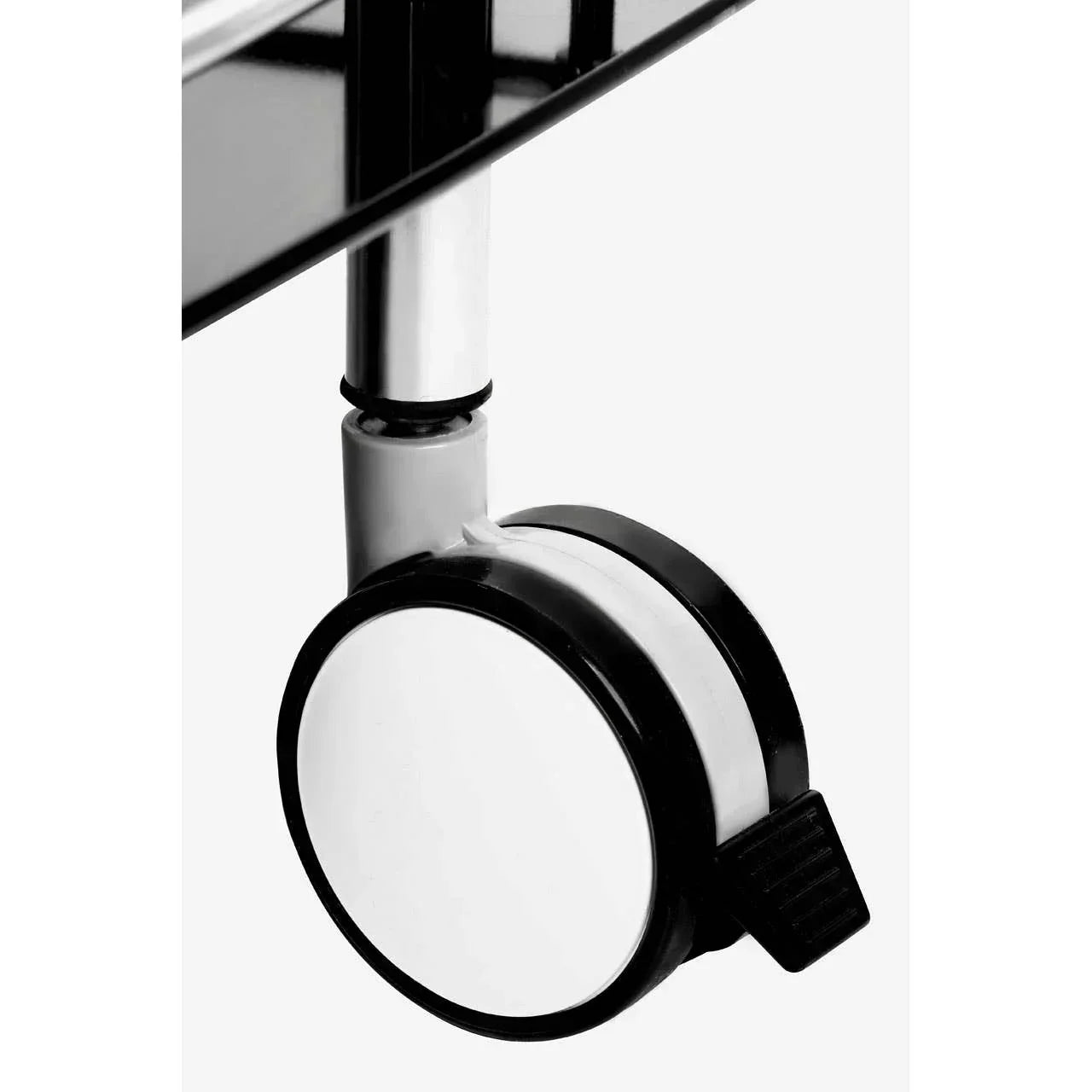 Close-up of furniture caster wheel with locking brake on chrome leg and black glass shelf