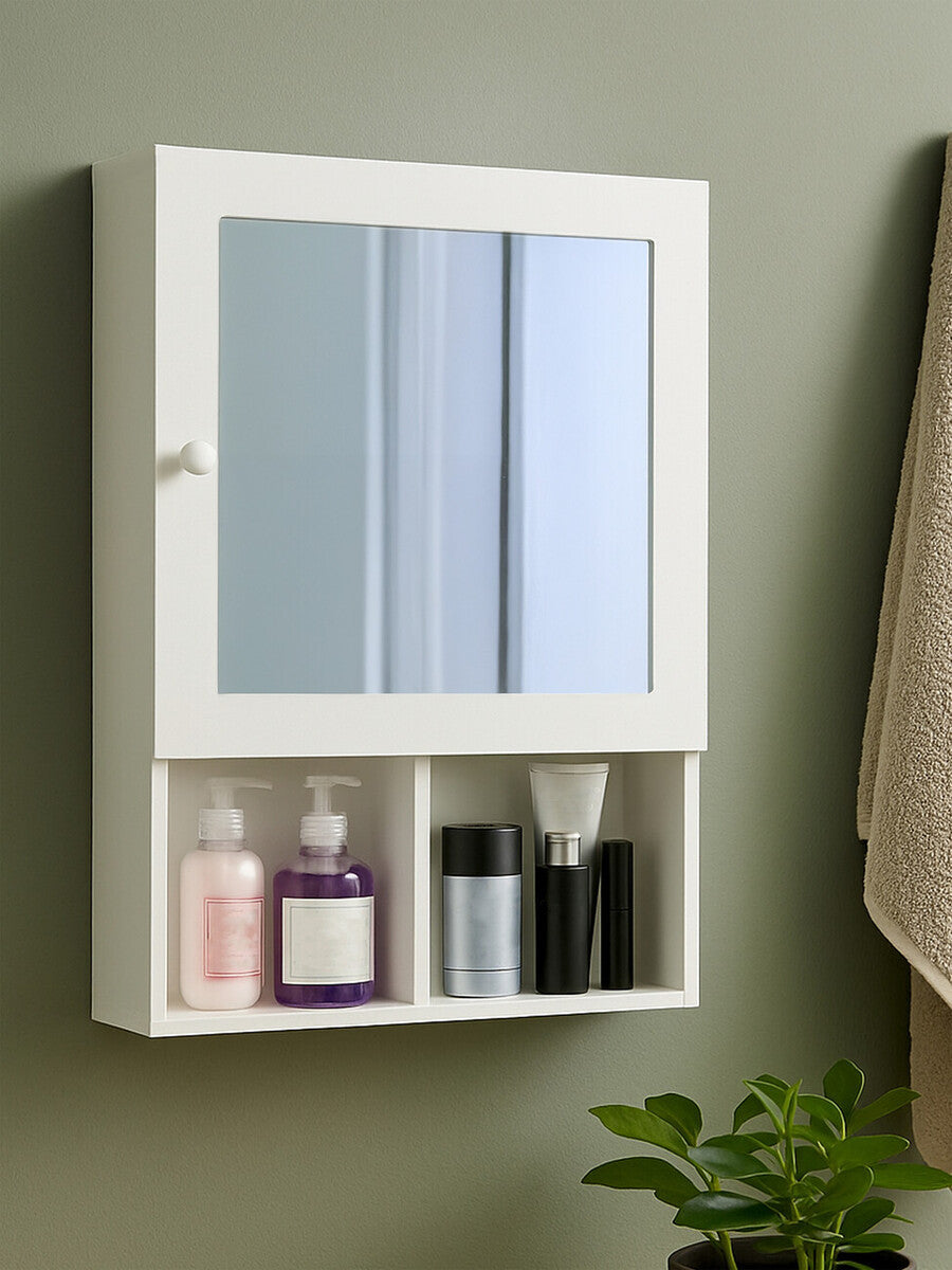 White wood mirrored cabinet with two mirrored doors and an open shelf below, displaying various bottles and containers. The cabinet is mounted on a wall with a neutral-colored background and a towel hanging nearby