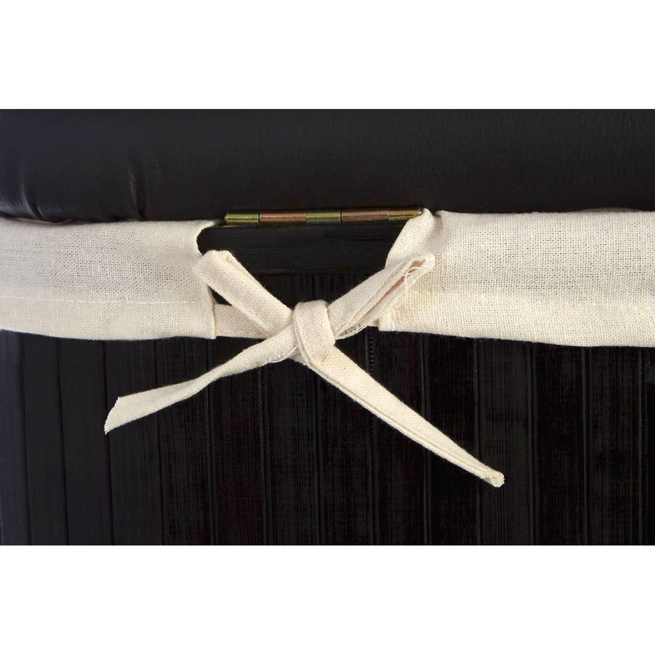 Close-up of fabric tie and hinge detail on dark woven storage bench with cushion