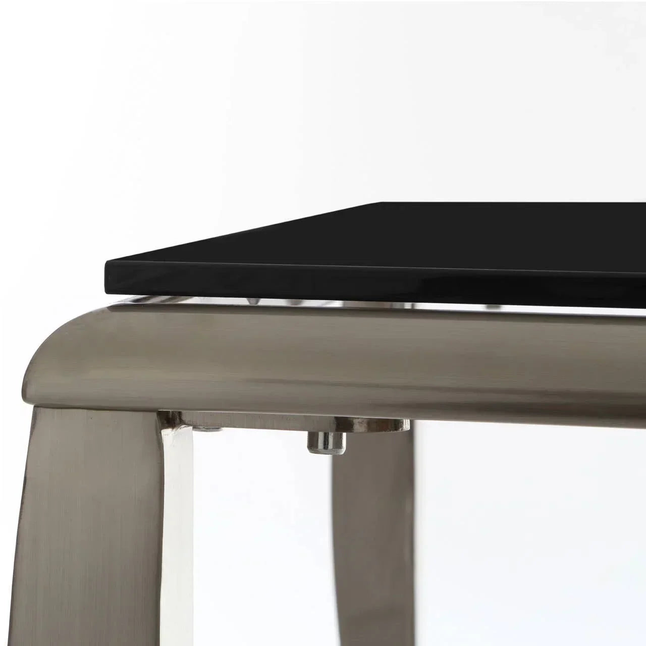 Close-up of black glass dining table top with brushed metal frame