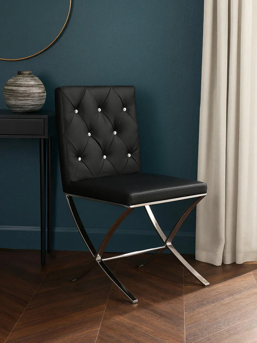 Black leather dining chair with diamond tufted back and chrome legs on wood floor