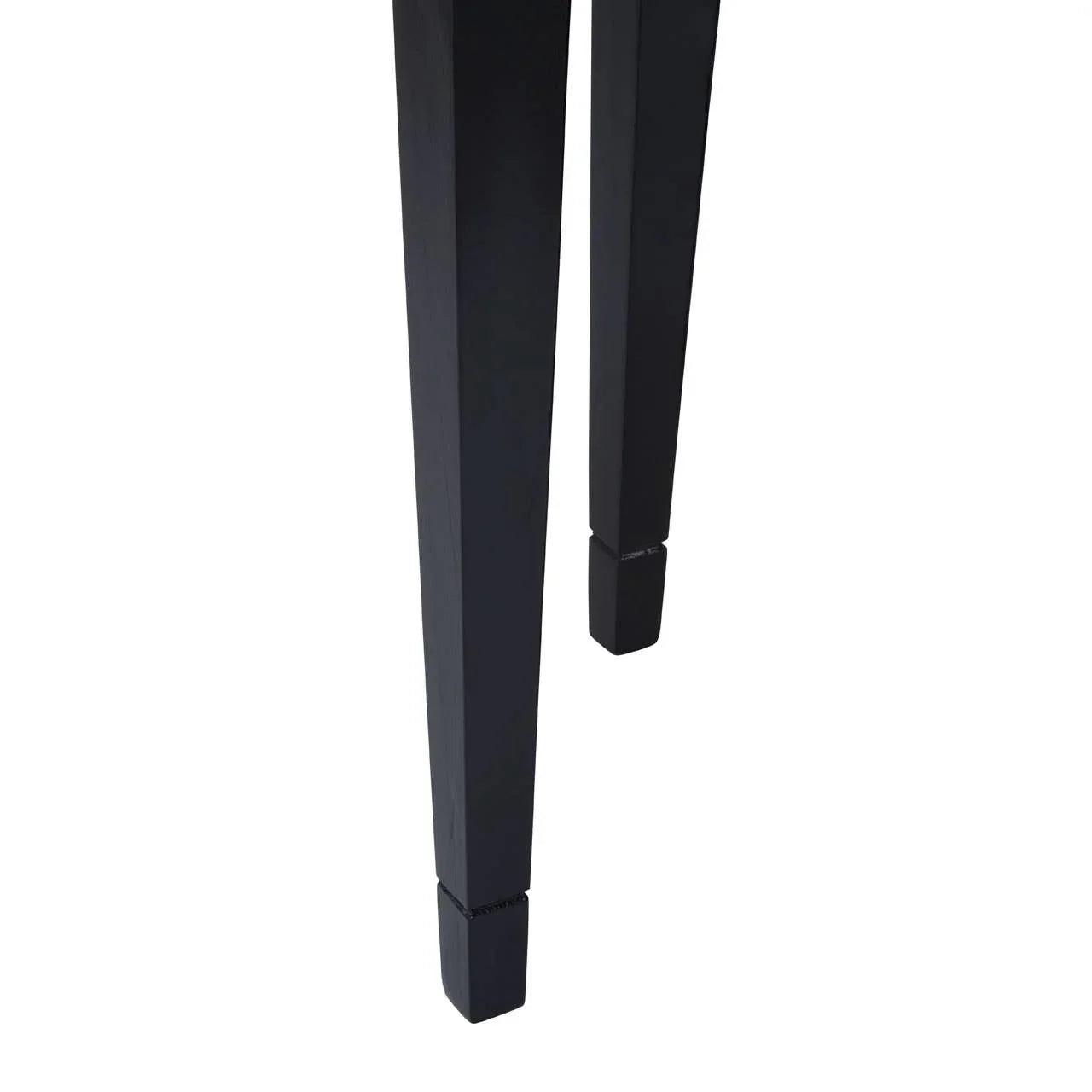 Closeup of black wooden dining table legs with tapered square design