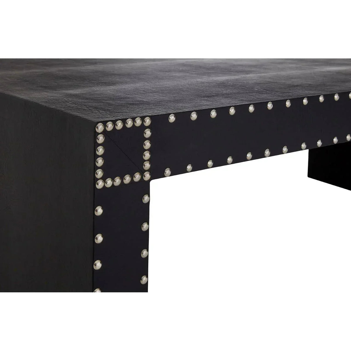 Black dining table with silver studded trim detail and textured surface closeup