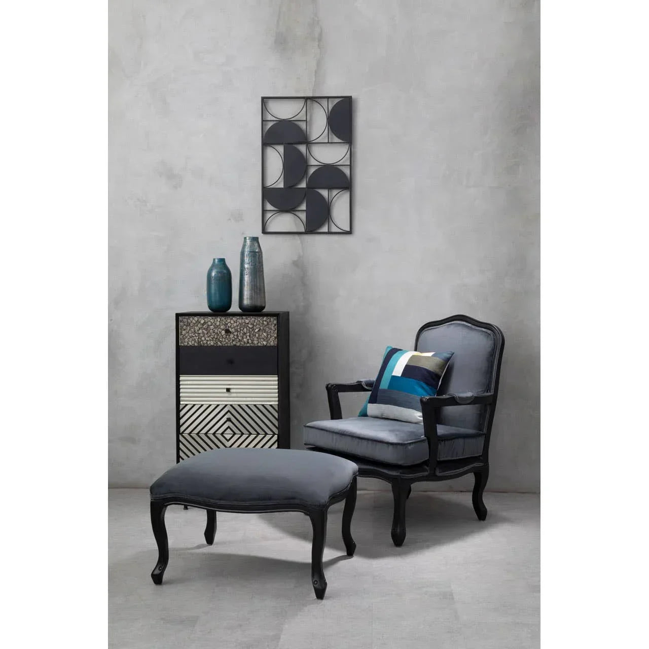 Grey upholstered accent chair with footstool, geometric cushion and art deco side cabinet
