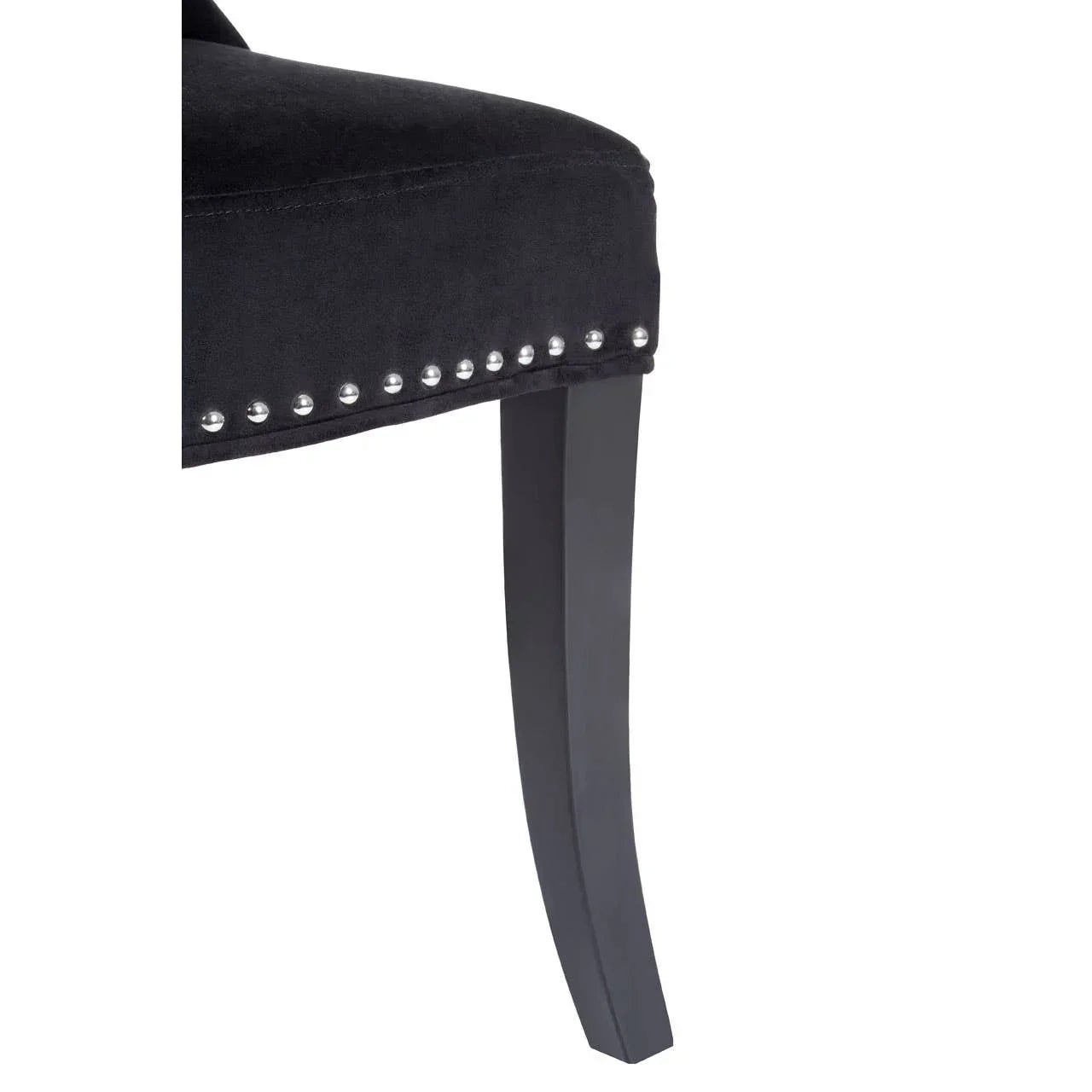 Black velvet dining chair with studded detail and dark wooden leg close-up
